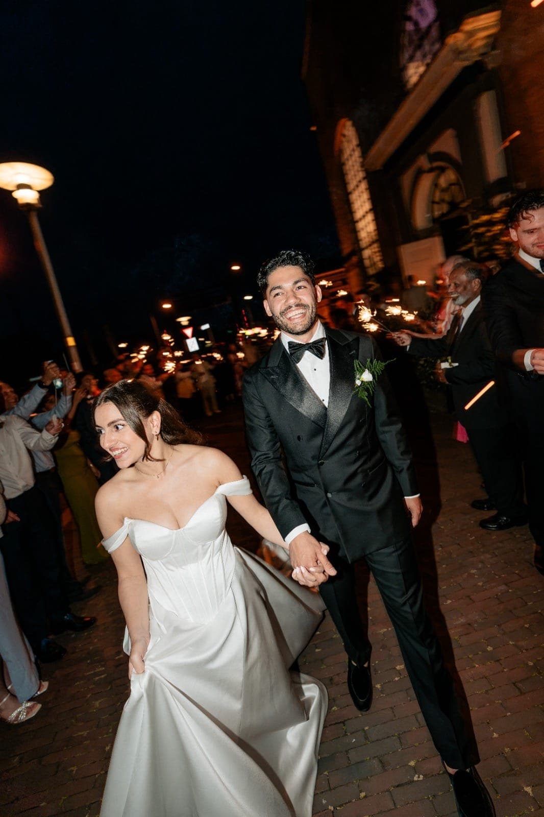 Bride and groom during their sparkler exit at night outside a Maltese church